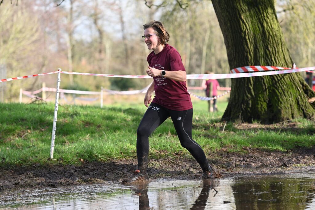 Woman runner running through muddy water