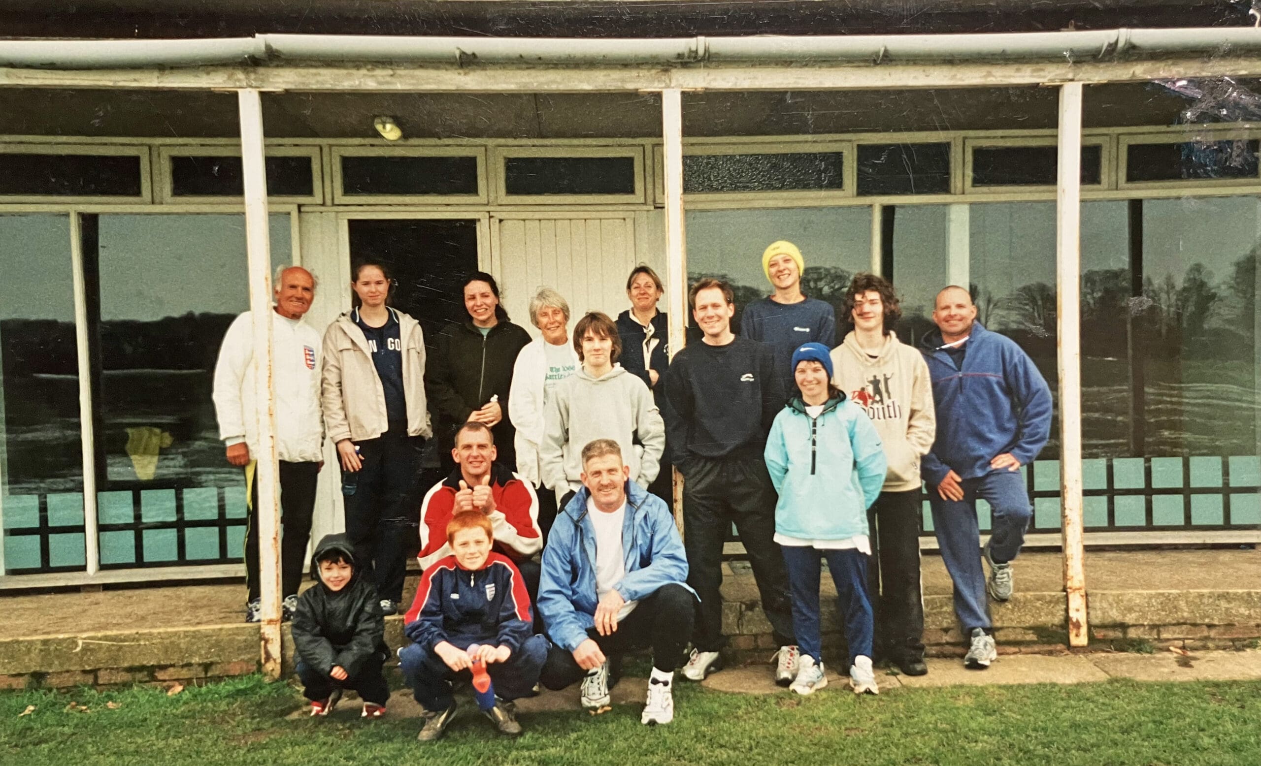 Group of people wearing track suits stood in front of a club house